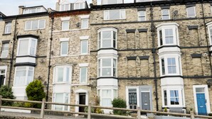 A row of terraced houses with bay windows and white doorways. - Marina View (Whitby)