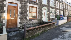 A row of terraced houses with stone facades, wooden doors, and windows. - Tryfan (Caernarfon)