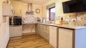 A modern kitchen with a microwave, oven, and dishwasher. - Kingfisher (Diss)