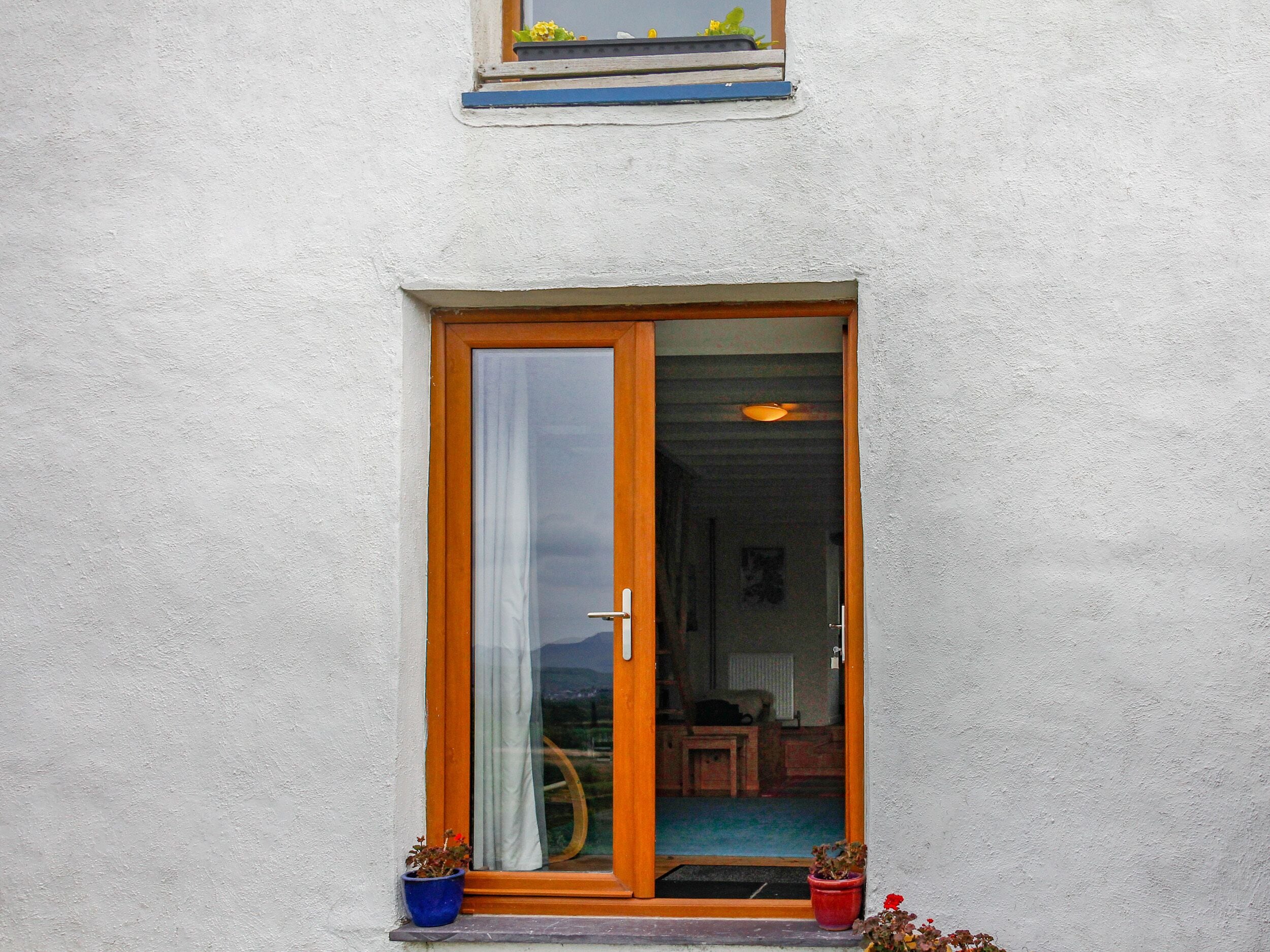 A door with a glass panel, a wooden frame, and a white curtain.