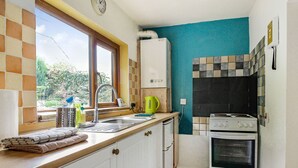 Una cocina con un lavabo, estufa y ventana.