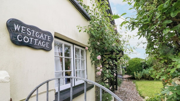 En hytte med et skilt, der viser 'Westgate Cottage'.