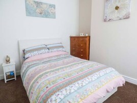Un dormitorio con una cama, un aparador y una mesita de noche.