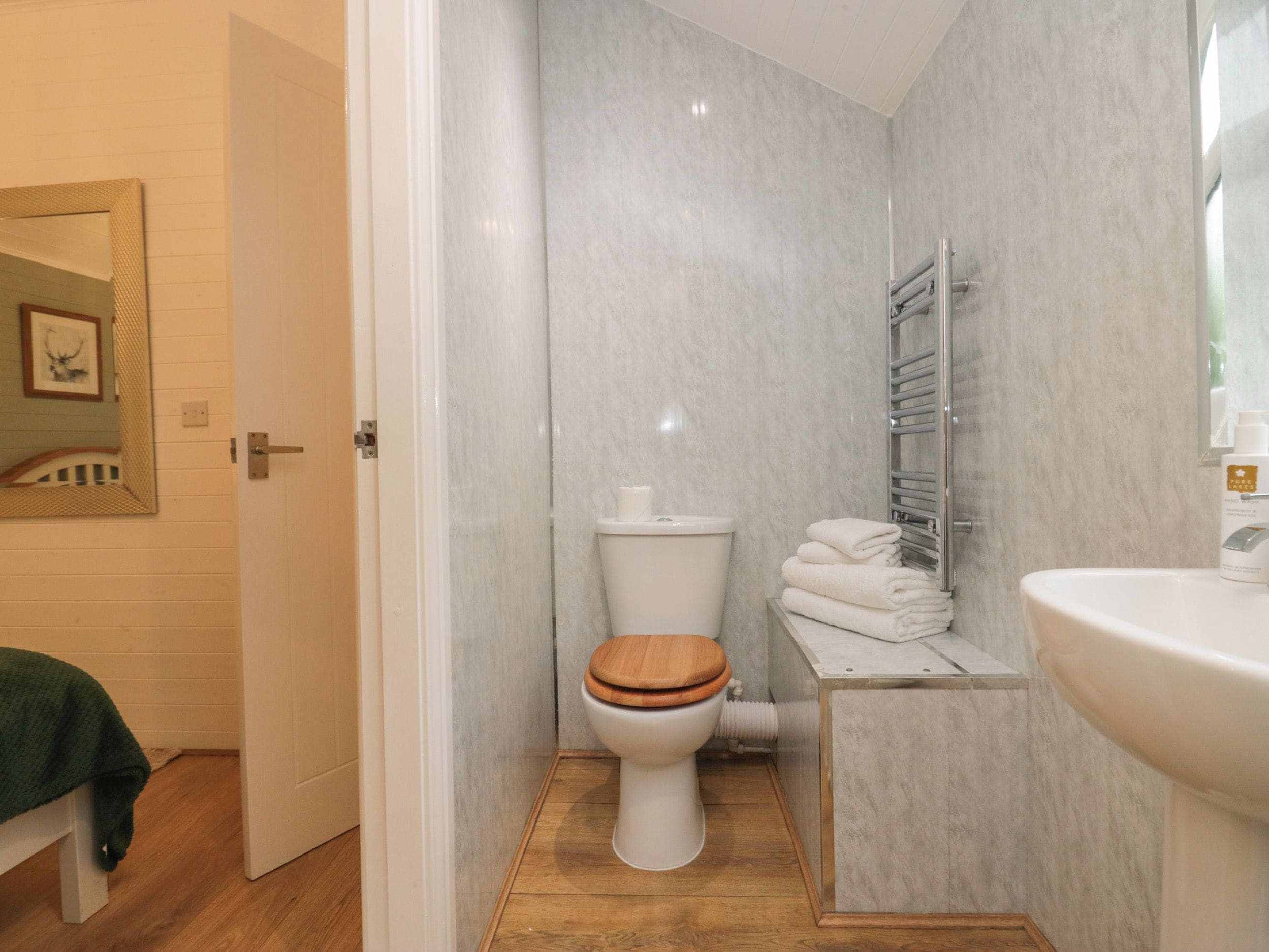 A compact bathroom with a toilet, a sink, and a shower area.