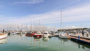 A marina with various boats docked, calm water, and a clear sky. - The Old Dairy (Newport)