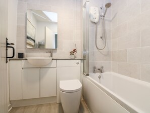 A modern bathroom with a sink, toilet, and bathtub. - Bell Cottage (Penzance)