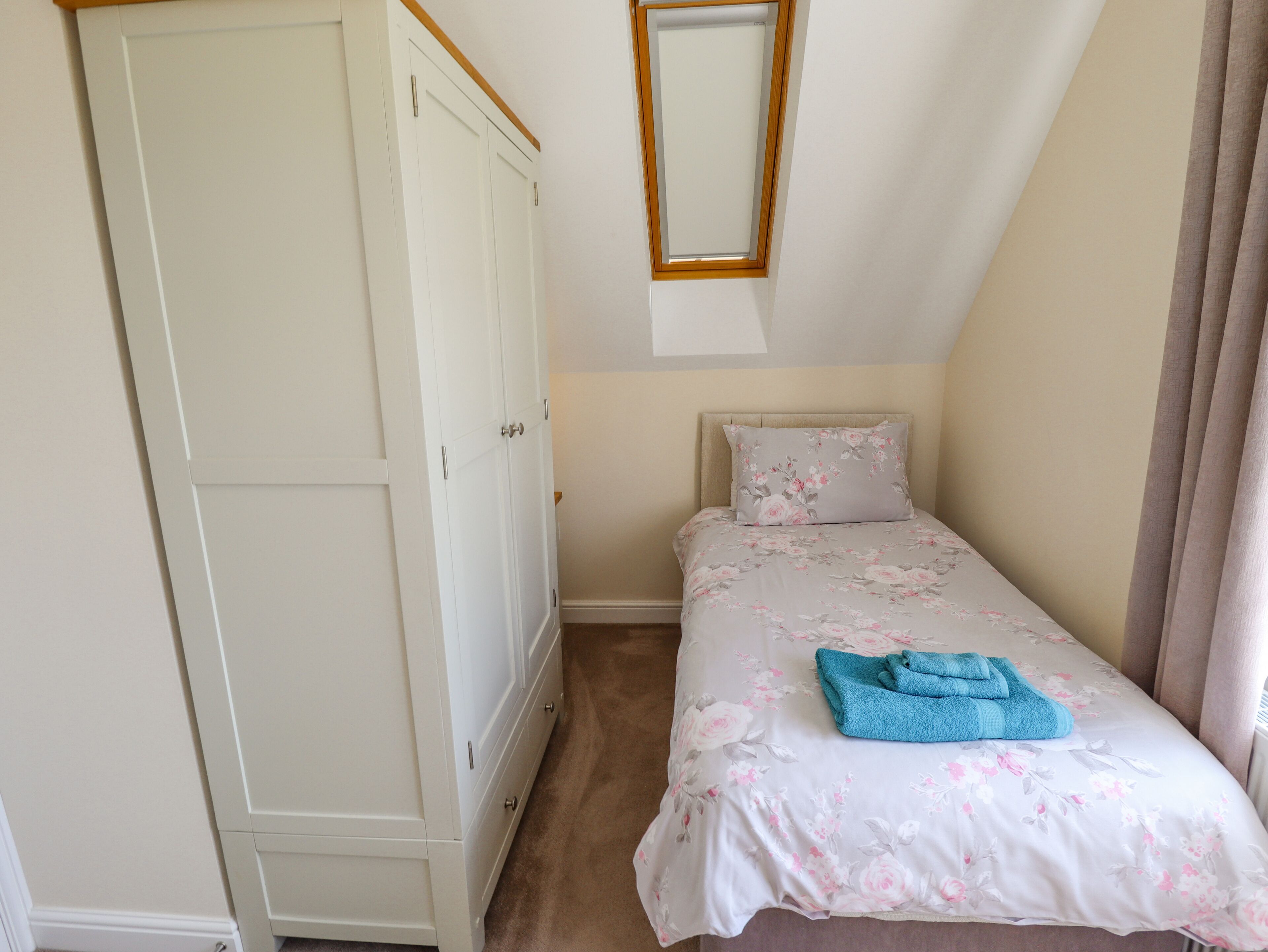 A bedroom with a bed, a wardrobe, and a mirror.