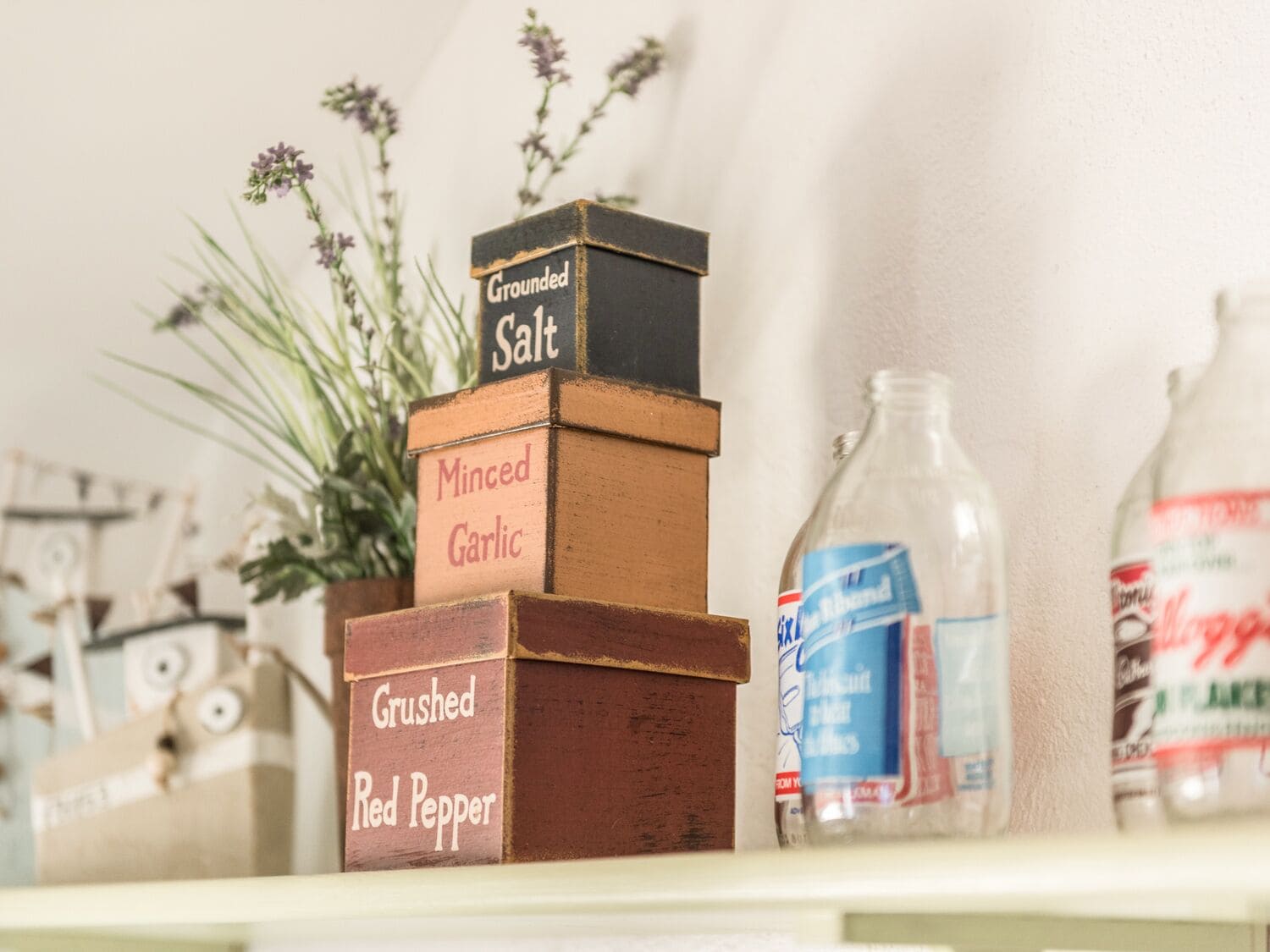 A stack of spice containers labeled Grounded Salt, Minced Garlic, and Grushed Red Pepper.