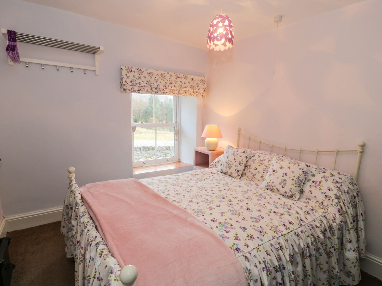 Quarto com cama, janela, abajur e luminária pendente.