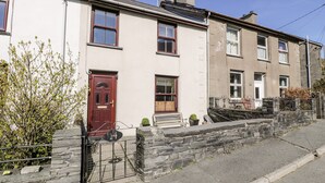 A row of terraced houses with a stone wall and a metal gate. - Miners Cottage (Blaenau Ffestiniog)
