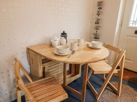 Un tavolo da pranzo in legno con stoviglie di ceramica bianca, circondato da sedie in legno.
