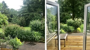 A wooden deck with a glass door leading to a garden. - Low Garth Cottage (Penrith)
