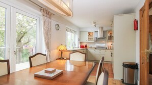 A dining area with a wooden table, chairs, a lamp, and a view of the kitchen and garden. - Riverdale (Shrewsbury)