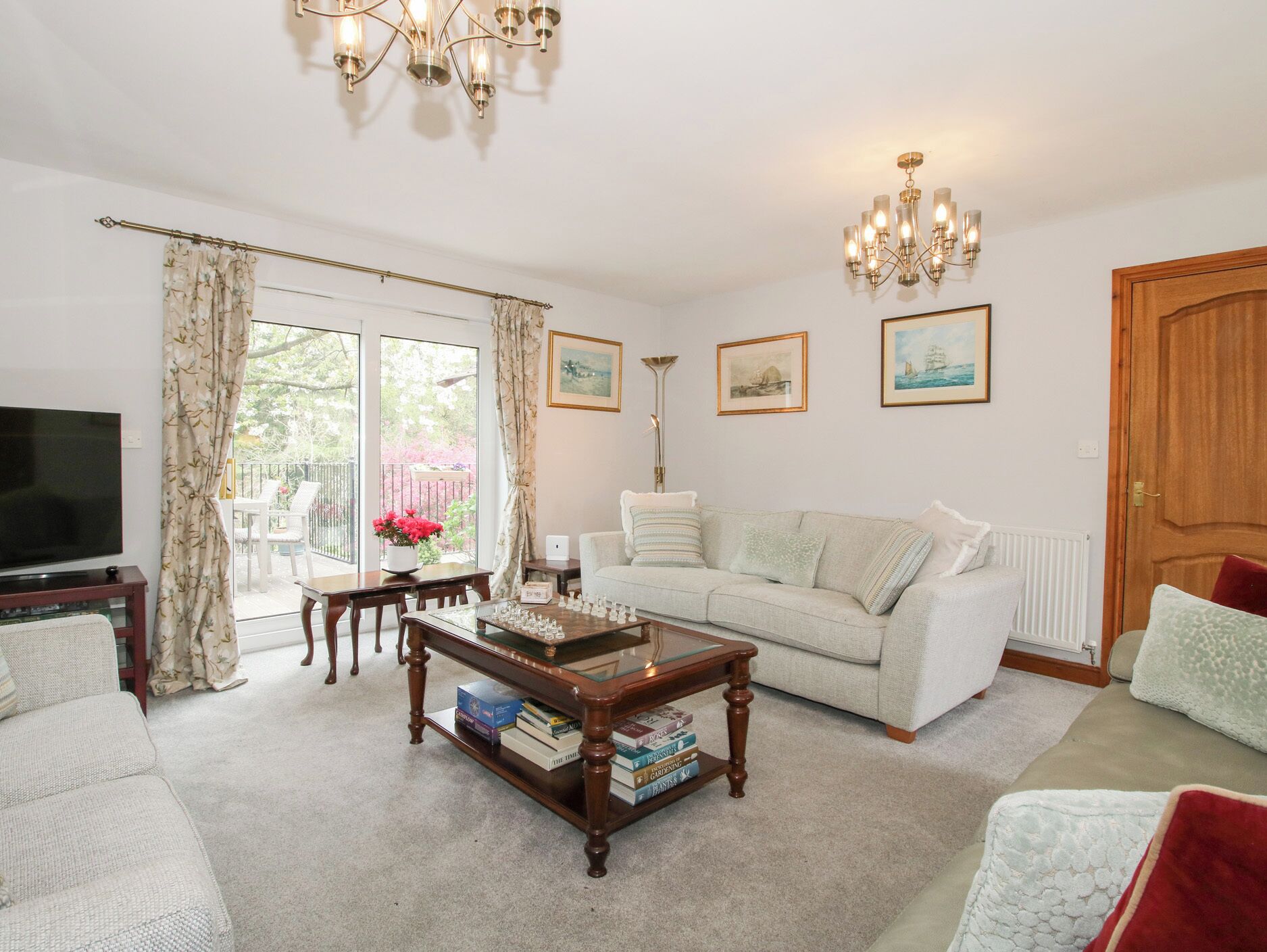 A living room with a sofa, coffee table, TV, and a dining area with a table and chairs.