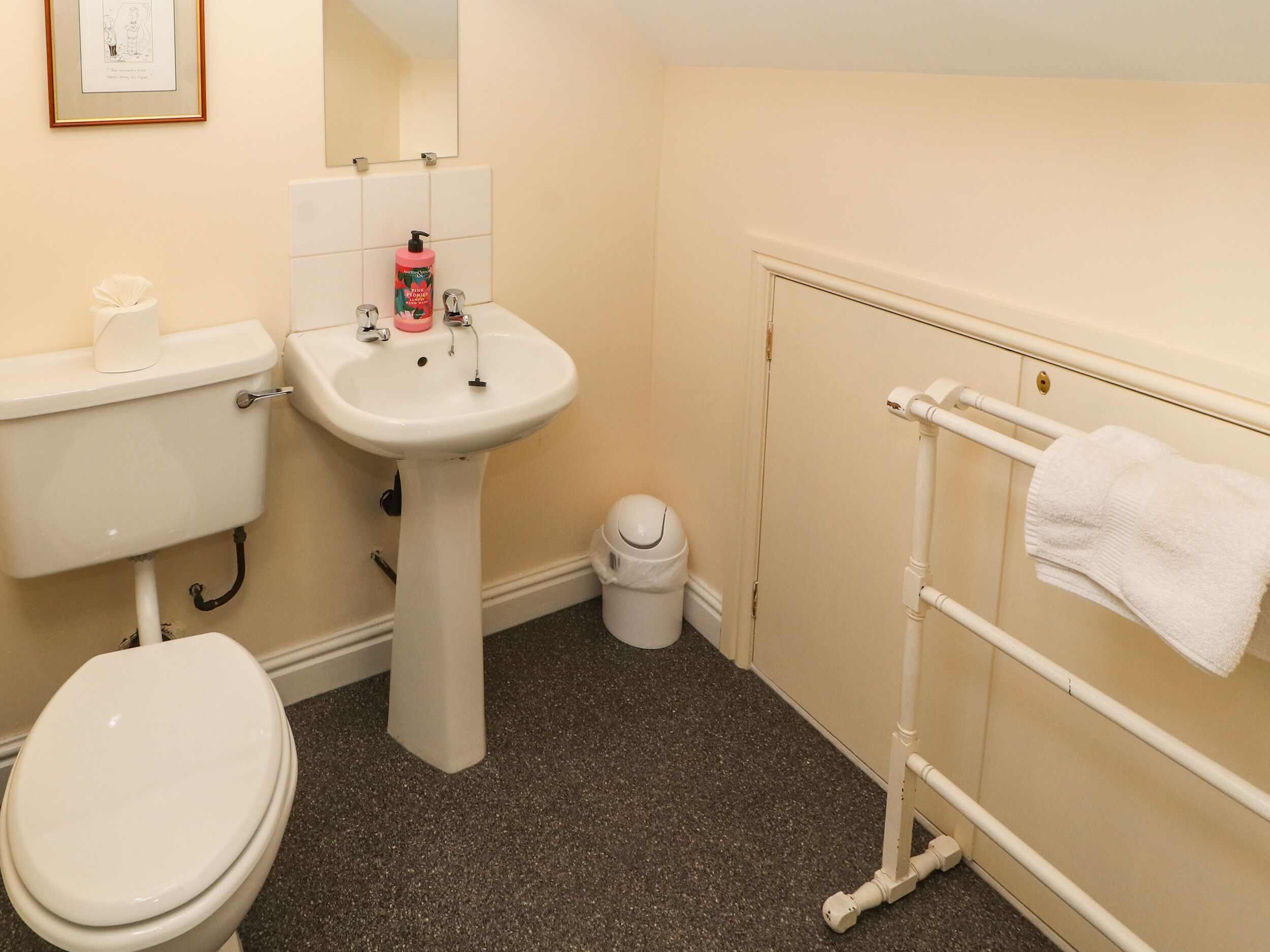 A small bathroom with a toilet, sink, and towel rack.