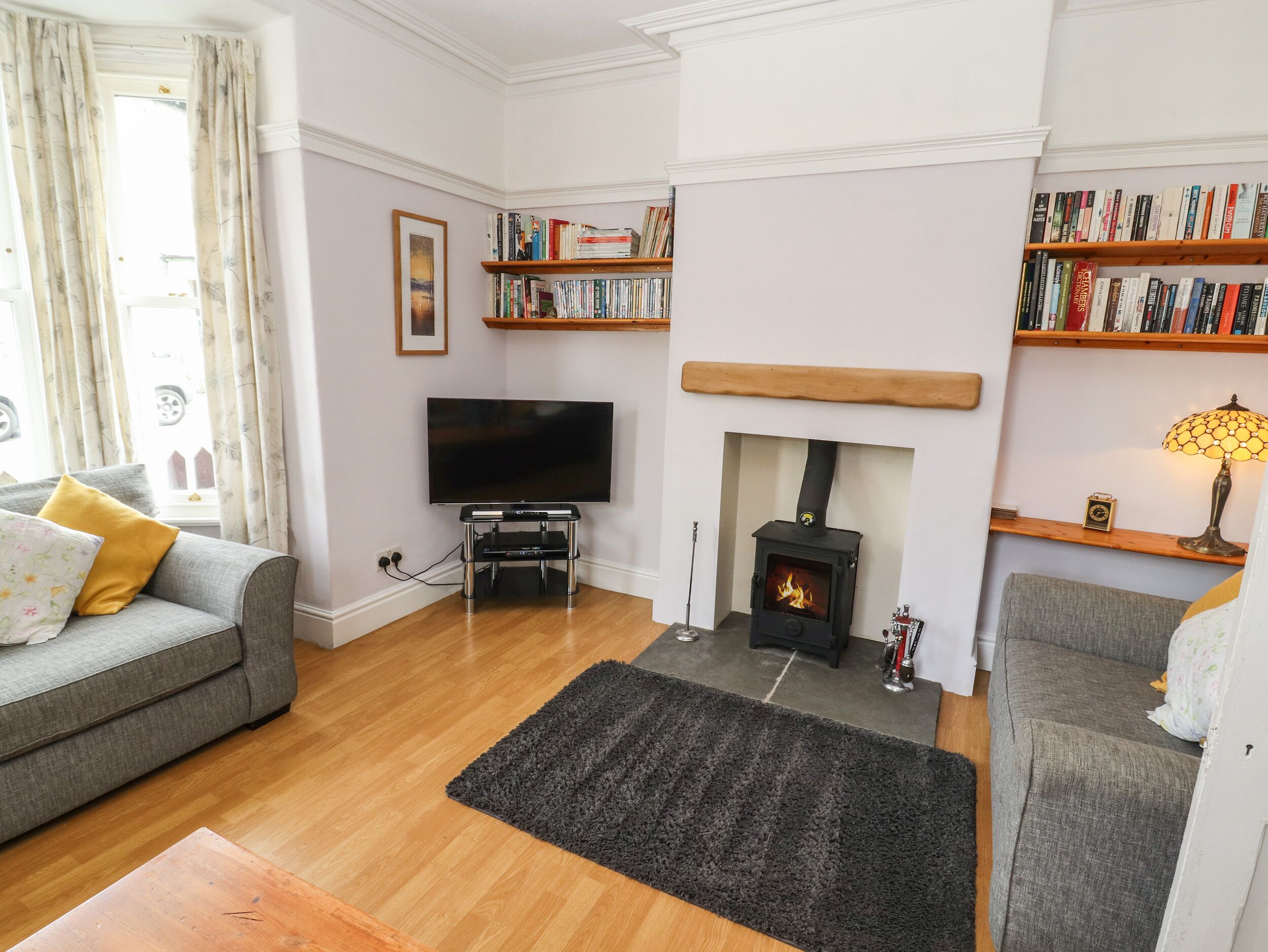 A living room with a fireplace, a television, and bookshelves.