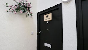 A black door with a wooden plaque reading "TREETOPS" and the number 6. - Treetops (Windermere)