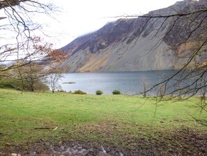 A lake surrounded by mountains and a grassy area.