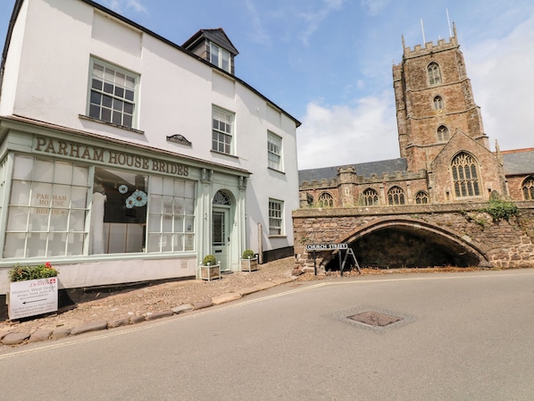 A white building with a sign reading "Parham House Brides" and a stone tower in the background. - Castle View (Minehead)