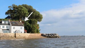 A coastal house with a stone wall and a large tree. - 1 The Quay (Exmouth)