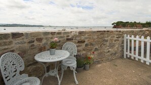 A stone wall with a white picket fence, a round table, and two ornate chairs. - 1 The Quay (Exmouth)