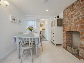 Enjoy cooking in this well-equipped kitchen with an oven, dining area, and rustic brick fireplace.