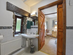 Bathroom features a stone-framed window, sink, and mirror.