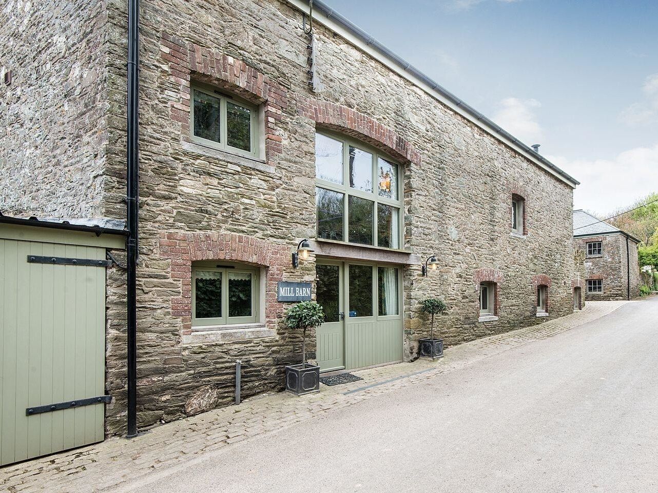 A stone building with a sign reading "Mill Barn."