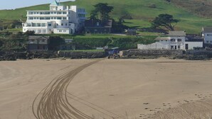 A coastal building with multiple floors, a prominent green roof, and a sign reading "PILCHARD INN". - Torrings Barn (Kingsbridge)