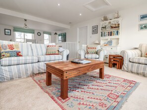 Cozy living space with a striped sofa, wooden coffee table, and armchair.