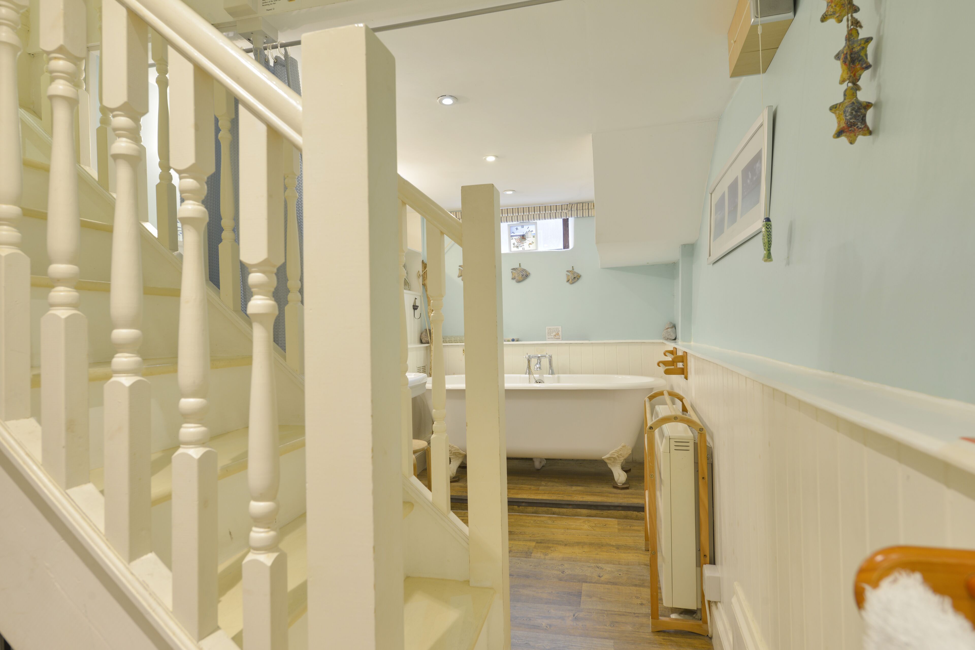 A staircase leading to a bathroom with a bathtub, a sink, and a toilet.