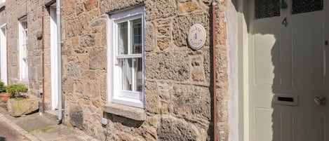 A stone building with a white door and a window.