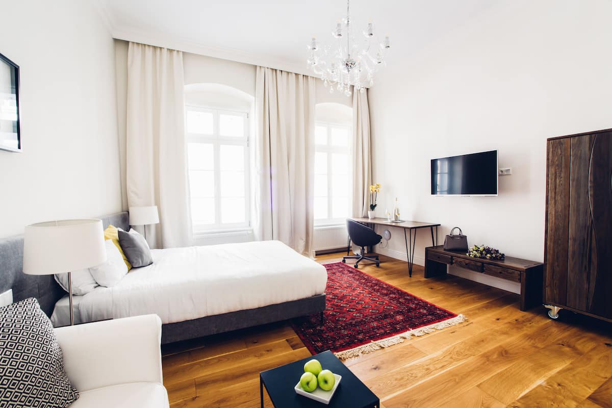 Ein modernes Hotelzimmer mit einem großen Bett, einem Schreibtisch, einem Fernseher und einem Kleiderschrank.