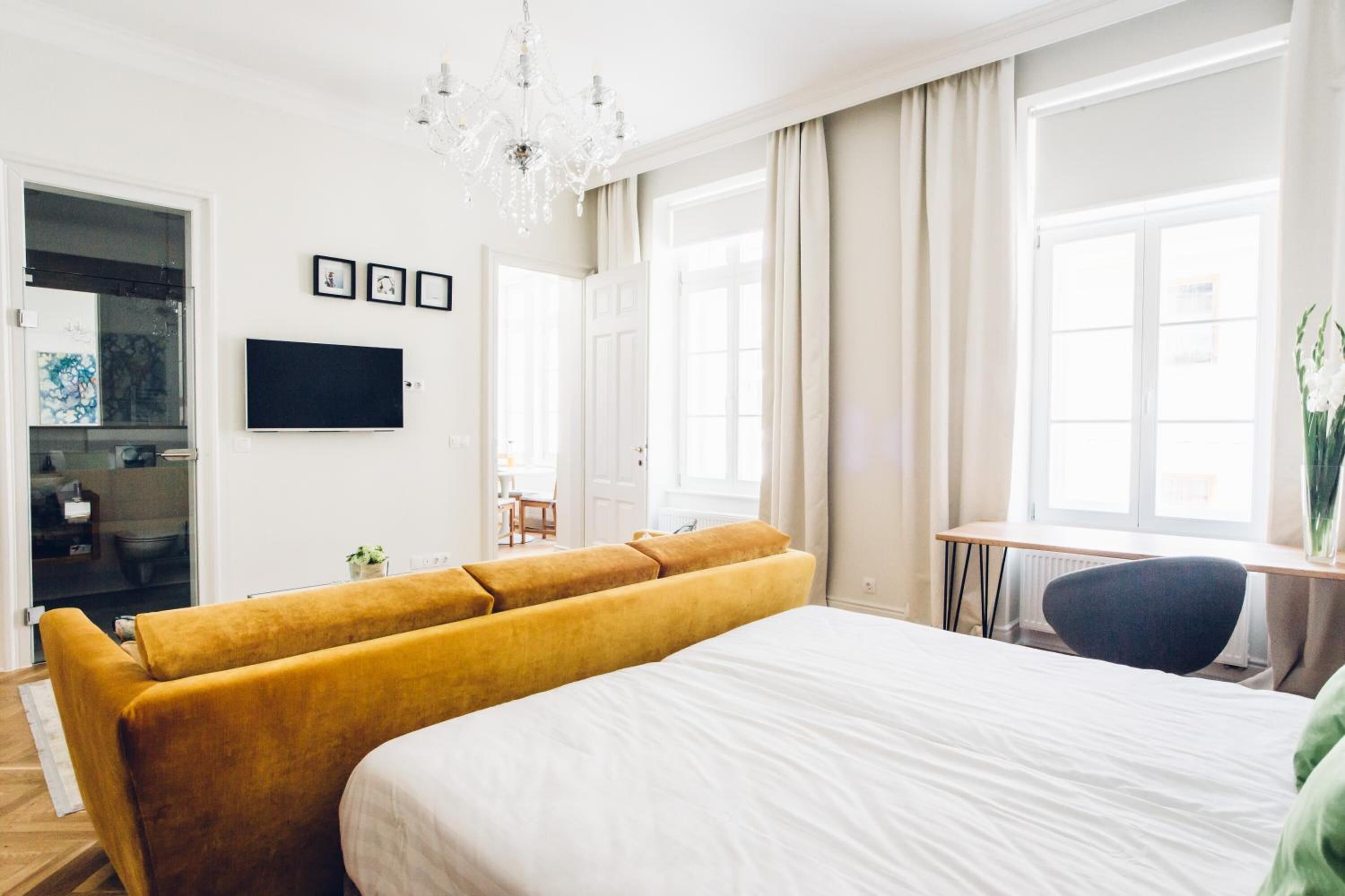 Une chambre d’hôtel moderne, dotée d’un grand lit, d’un canapé, d’un bureau et d’une télévision.