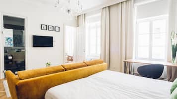 Une chambre d’hôtel moderne, dotée d’un grand lit, d’un canapé, d’un bureau et d’une télévision.