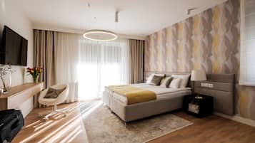 Una habitación de hotel moderna con cama, mesita de noche, lámpara y televisor.