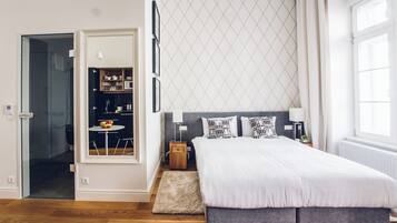 Un dormitorio moderno con una cama grande, una mesita con fruta, un armario y una ventana con cortinas.