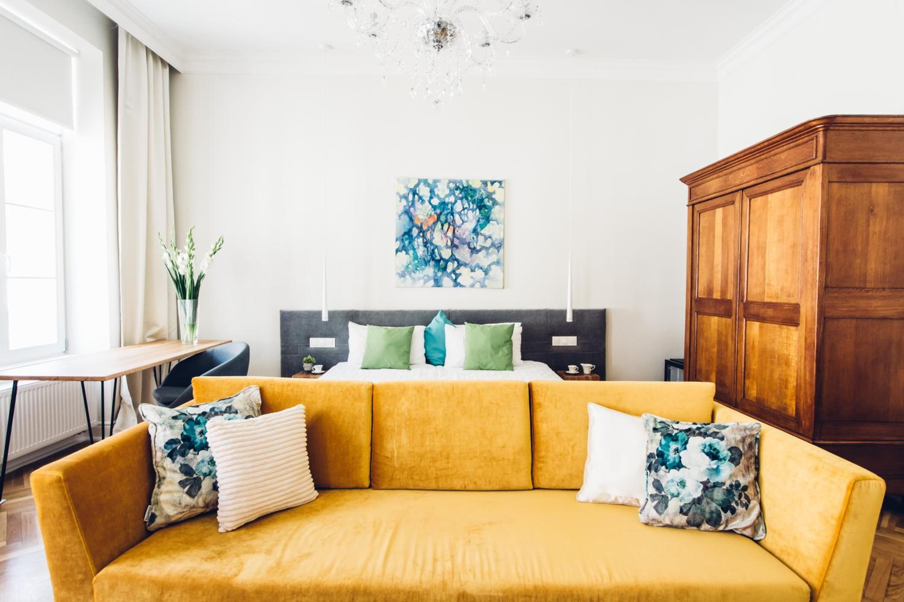Una sala de estar moderna con un sofá amarillo, un mueble de madera y un cuadro en la pared.