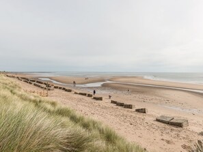 A beach with a wooden walkway and grassy dunes. - Jackson Cottage (Alnwick)