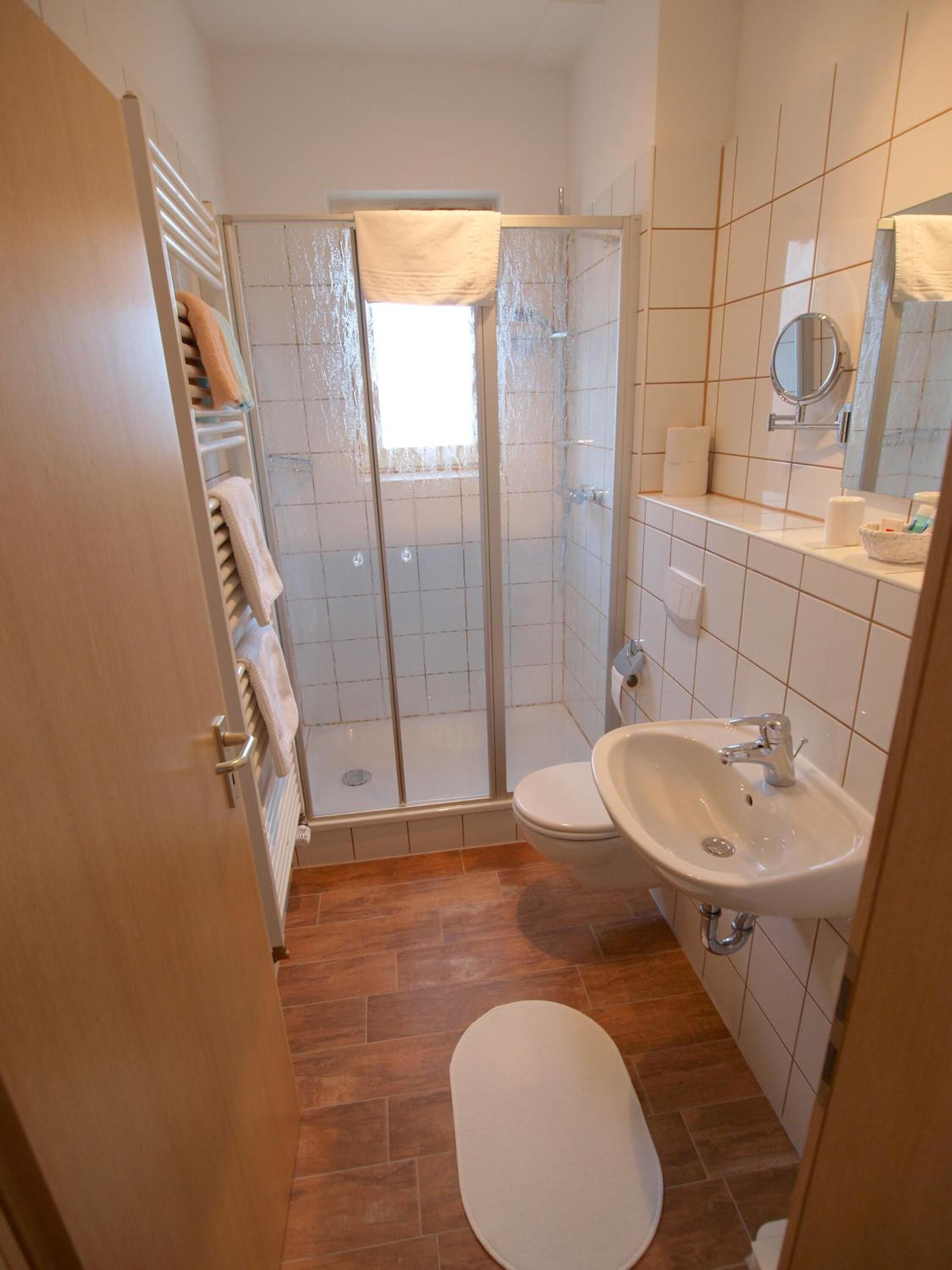 Ein Badezimmer mit Dusche, Toilette und Waschbecken.