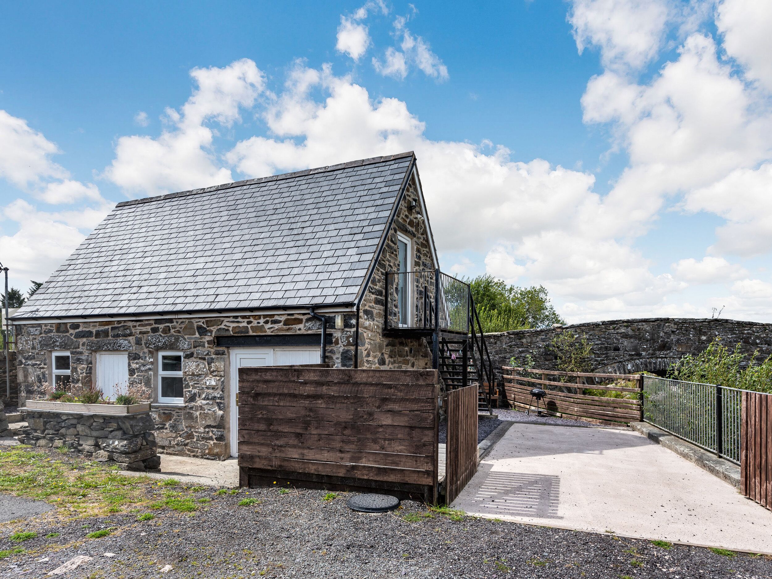 A stone building with a sloped roof and a wooden door.