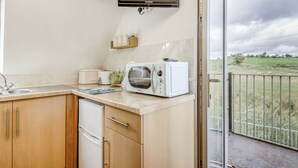 Een keuken met een ingebouwde oven, een broodrooster en een spoelbak.