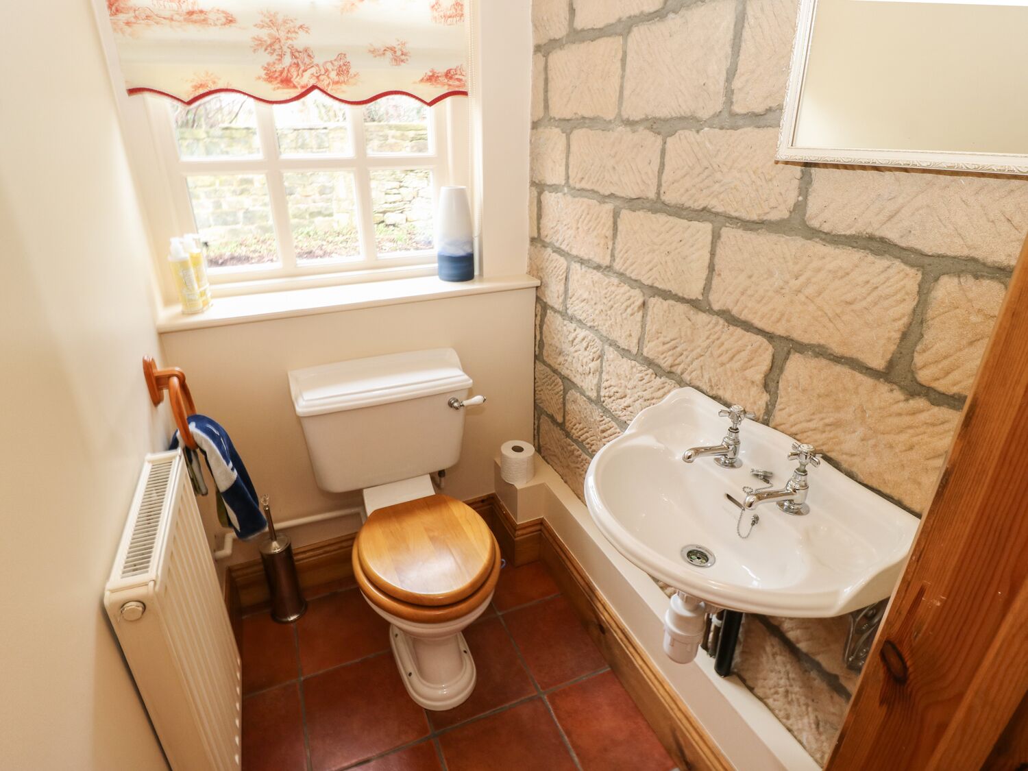 A bathroom with a toilet, a sink, and a window.