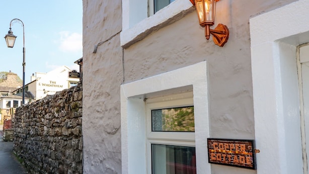 Un edificio blanco con muro de piedra, un cartel que dice 'The Lethwaite Arms' y un cartel que indica 'Coffee House'.