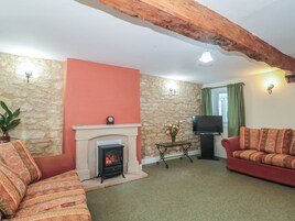 Una sala de estar acogedora con chimenea, televisor y sofá.