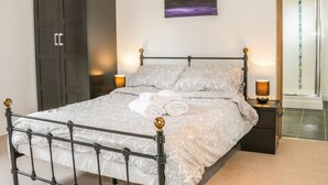 Ein Schlafzimmer mit Bett, Schrank, einem Bild und einem durchgegangenen Tür sichtbaren Badezimmer.