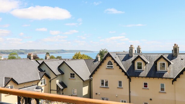 A row of houses with a view of the sea and hills in the background. - 24 Rhodewood House (Saundersfoot)