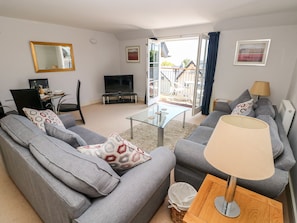 Relax in this stylish living room with a comfortable sofa, flat-screen TV, and a large window offering a view of the outside.