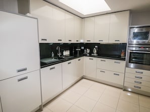 Enjoy cooking in this well-lit kitchen with sleek cabinetry and an oven.
