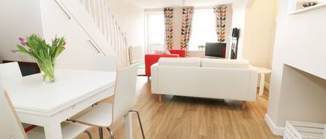 Un apartamento moderno con comedor, sala de estar y escalera.